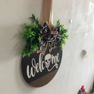 Detail of wooden Welcome sign with skull icon and black white ribbon for Halloween