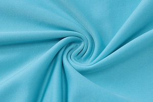 Primo piano della trama del tessuto a maglia blu e del morbido drappeggio dell'abito con scollo a V