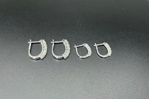 Macro detail of 925 sterling silver U-shaped hoop earrings with sparkling moissanite stones