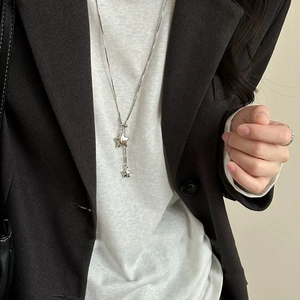 Silver Y-shaped star pendant long necklace worn on white top and dark blazer