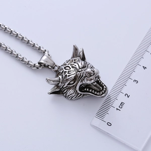 Macro shot of silver gothic wolf head pendant with measurement ruler for size details