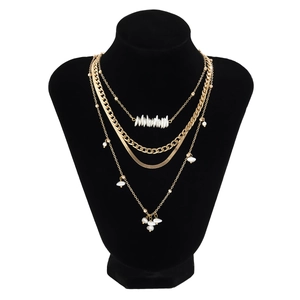 Layered gold necklace set featuring irregular pearls, Cuban chain and sleek snake chain