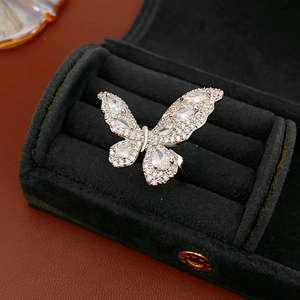 Macro shot of a silver butterfly ring with cubic zirconia inlay on a black velvet box