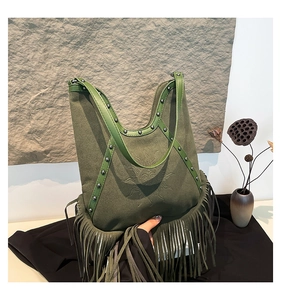 Close-up of army green bohemian tassel bag with sun totem pattern and silver rivets