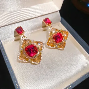 Vintage style floral earrings with red crystal and pearl studs in a jewelry box