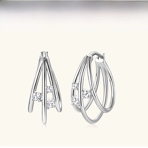 Detail of silver triple interlocking hoop earrings with three inlaid zircon stones