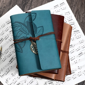 Vintage leather traveler notebook with leaf embossing and metallic leaf pendant decor