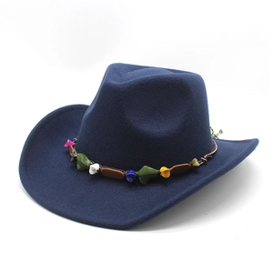 Close-up of ethnic braided rope with colorful stones on dark blue felt wool cowboy hat
