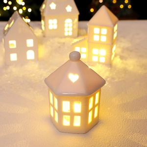 White ceramic Christmas house candle holders with heart and star cutouts for festive decor