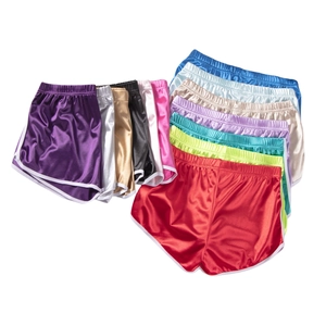 Macro detail of silky satin sports shorts showing multiple vibrant colors and white trim