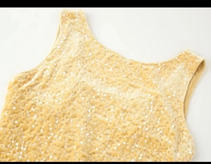 Detailed view of champagne gold sequined fabric on velvet sleeveless top with wide straps