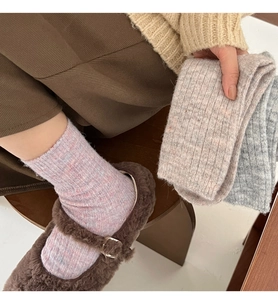 Close-up of soft gradient wool socks in pink, beige and grey knitted texture