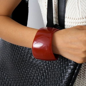 Macro detail of wide red resin geometric cuff bracelet with high-gloss mirror finish