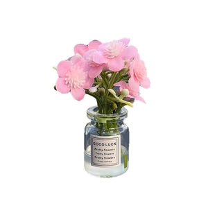 Luminous artificial pink flower in glass bottle with Good Luck label desktop ornament