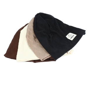 Close-up of diamond-pattern knit beanies with graceful fabric labels in four colors