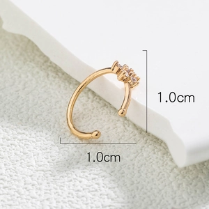 Macro detail of golden U-shaped fake nose ring with micro-set zircons measuring 1.0cm