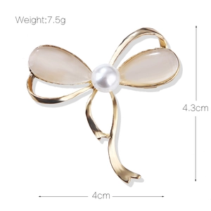 Elegant gold bow brooch with cat eye stone inlay and pearl detail, 4.3cm x 4cm size