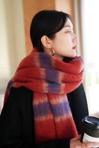 Detail of soft striped plush scarf with fringe tassels in red purple and blue shades