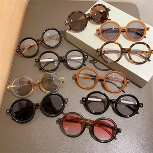 Collection de lunettes de soleil rondes rétro en noir et écaillé sur présentoirs étagés