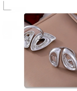 Detail of silver irregular hollow geometric ring with polished liquid metal texture