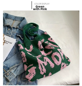 Detail of green and pink knitted tote bag with textured jacquard pattern on a white cloth