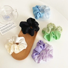 Detailoverzicht van vijf diverse satijnen en kant haare kanten haarelastiekjes in pastelkleuren