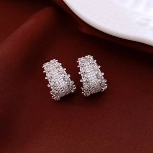 Detailed close-up of silver-tone C-shaped earrings with micro-pave cubic zirconia crystals
