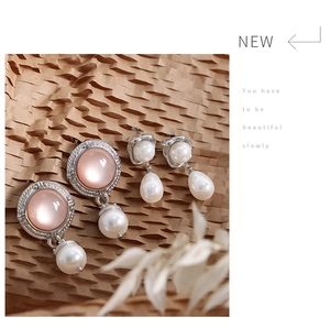 Detail of elegant silver drop earrings featuring pink cat eye stone and white pearls