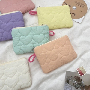 Detailed view of quilted heart-shaped macaron mini pouches in six pastel colors