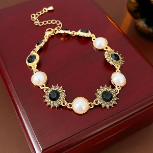 Vintage gold sunflower bracelet with pearls and rhinestones on a red jewelry box