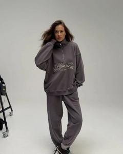 Close-up of oversized dark grey half-zip sweatshirt with Pleasure embroidery detail