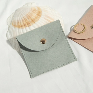Macro shot of light green microfiber jewelry pouch with gold snap button and shell deco