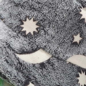 Detail of plush faux fur fabric with glow-in-the-dark moon and star patterns