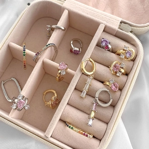 Macro shot of assorted gold and silver earrings with heart designs in a jewelry box