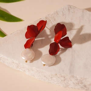 Detailed macro view of dark red matte flower earrings with a white freshwater pearl accent