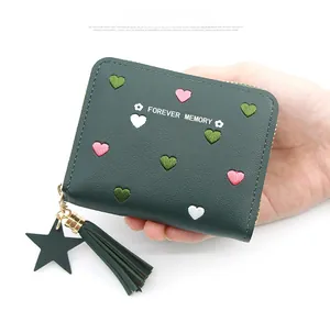 Detail of dark green wallet with heart embroidery, tassel and star metal pendant
