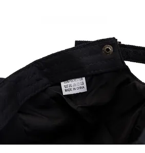 Detailed close-up of adjustable strap and 100% polyester label on a black flat cap