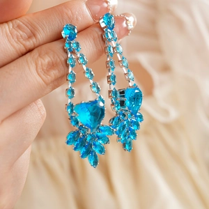 Detail of luxury teardrop blue crystal earrings with zircon accents and silver pins
