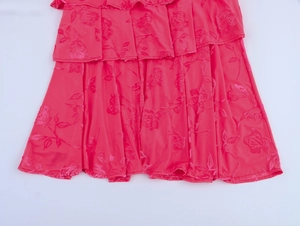Détail de robe rose à volants superposés avec textures florales en 3D et tissu délicat