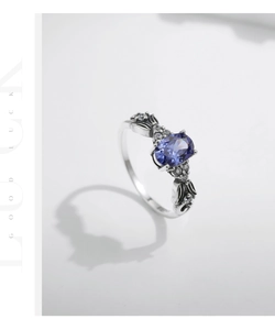 Macro view of vintage silver ring with oval purple gemstone and petite white zircons
