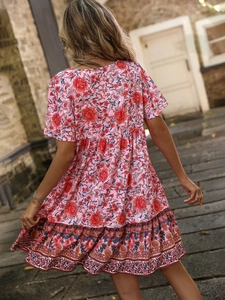 Bohemian floral V-neck dress for women in pink with back view on a vintage street