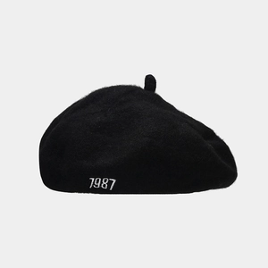 Close-up of the detailed 1987 white embroidery on a black wool beret painter hat