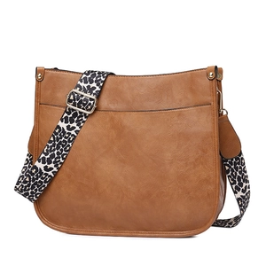 Detail of a brown PU leather tote bag with a leopard print wide shoulder strap