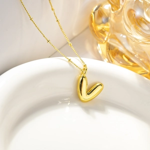 Dettaglio della collana con pendente a V stile palloncino placcata in oro 18K e catena
