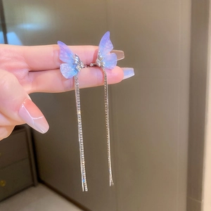 Detail of butterfly ear cuff with purple gradient wings and long sparkling tassels