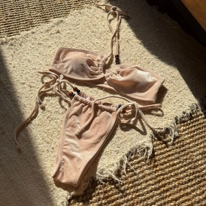 Detailed view of champagne velvet bikini with elegant beads on ties and glossy fabric