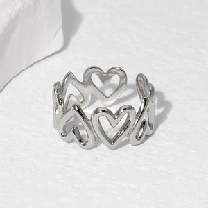 Minimalist open heart ring in silver stainless steel on white stone surface
