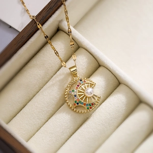 Chic gold necklace with crescent moon, sun pendant, zircon and pearl in a jewelry box