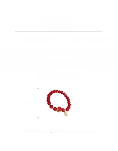 Détail montrant les perles en verre rouge et le charme doré avec informations de taille