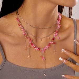 Detail showing pink resin flower multi-layer necklace with water drop tassel on female model